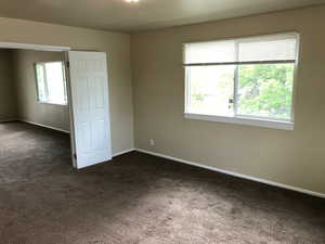 Unfurnished bedroom with dark colored carpet