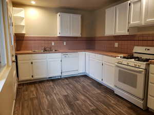 Kitchen with white appliances, tile countertops, white cabinetry, dark wood finished floors, and recessed lighting