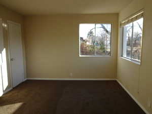 Unfurnished room with dark colored carpet and plenty of natural light