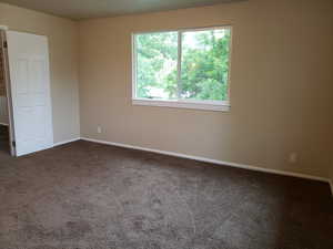 Carpeted spare room with baseboards