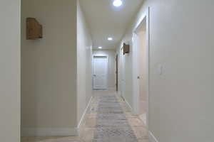 Hall with recessed lighting and baseboards