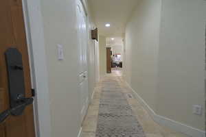 Corridor with a textured wall and recessed lighting