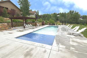 Community pool featuring a pergola and a patio area