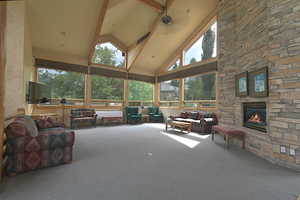 Sunroom with high vaulted ceiling, carpet floors, and beamed ceiling