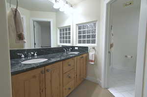 Bathroom with double vanity and tile patterned flooring