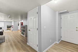 Hall featuring light wood-style flooring and baseboards