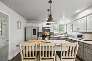 Kitchen with white appliances, backsplash, butcher block counters, dark wood-style floors, and gray cabinetry