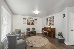 Sitting room with plenty of natural light and wood finished floors