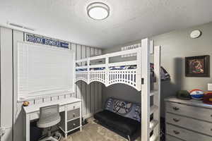 Bedroom with carpet floors and a textured ceiling