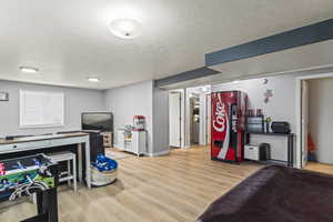 Game room featuring wood finished floors and a textured ceiling