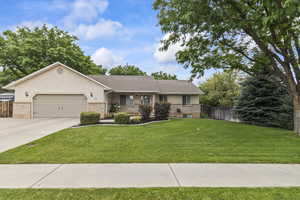 Ranch-style house with a garage, driveway, stucco siding, and brick siding
