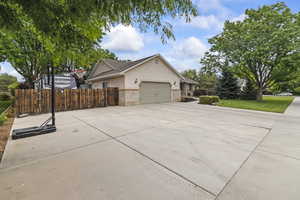 View of home's exterior featuring stucco siding, brick siding, a garage, and driveway