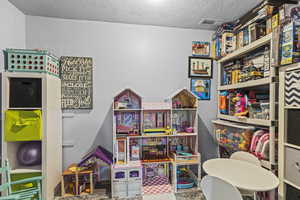 Game room featuring a textured ceiling and attic access