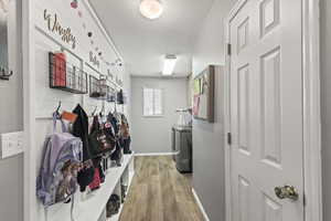 Mudroom featuring washing machine and clothes dryer and light wood-style flooring