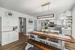 Dining space with dark wood finished floors and baseboards