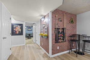 Hallway with wood finished floors and a textured ceiling