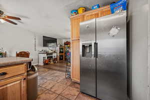 Kitchen featuring stainless steel fridge with ice dispenser, ceiling fan, and light tile patterned flooring