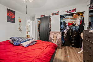 Bedroom with wood finished floors and a textured ceiling