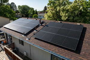 Exterior view of roof with shingles and solar panels