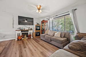 Living room with wood finished floors, a ceiling fan, and a textured ceiling