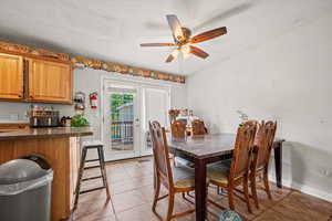 Dining room with light tile patterned floors, a ceiling fan, and a textured ceiling