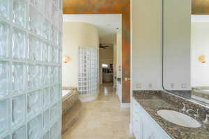 Bathroom with a garden tub, vanity, and tile patterned flooring