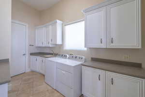 Washroom featuring washer and clothes dryer and cabinet space
