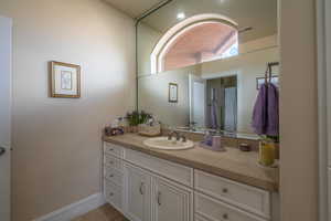 Full bath featuring vanity and baseboards