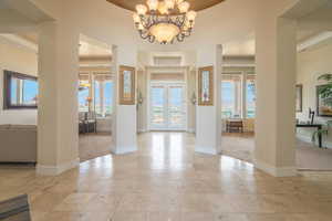 Foyer featuring plenty of natural light, light carpet, and a chandelier