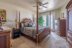 Bedroom featuring access to exterior, light carpet, and ceiling fan