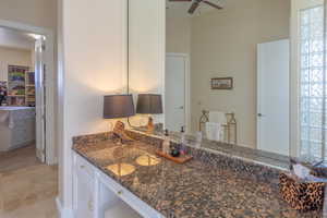 Kitchen featuring a ceiling fan, dark stone counters, and white cabinetry