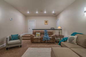Carpeted living area with baseboards