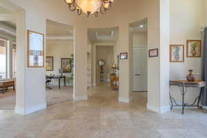 Entryway featuring a towering ceiling and a chandelier
