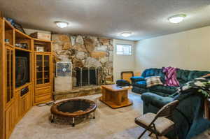 Carpeted living area with a textured ceiling and a fireplace