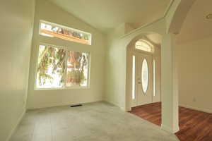 Entrance foyer featuring arched walkways and high vaulted ceiling