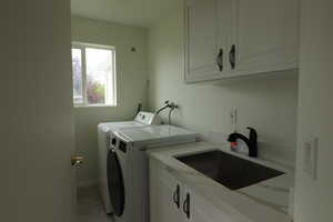 Washroom with cabinet space and washing machine and clothes dryer
