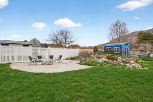 Fully fenced yard with a patio, fire pit,, workshed and water feature.