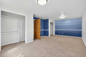 Bedroom 5. Large bedroom space with carpet flooring and two closets.