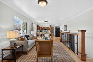 Open layout living room featuring a wood-burning fireplace and wood floors.