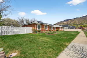 View of front of property featuring solar panels, brick siding, and a mountain view