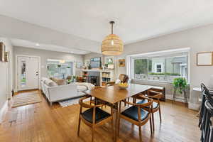 Dining area with light wood finished floors, healthy amount of natural light, a fireplace, and recessed lighting