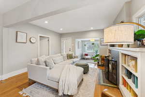 Living room with wood finished floors, a fireplace, and recessed lighting