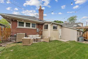 Back of house with outdoor lounge area, a chimney, and brick siding