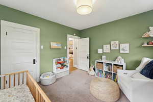 Bedroom with carpet and a crib