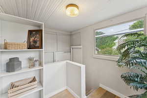 Hallway with light wood-style flooring and an upstairs landing