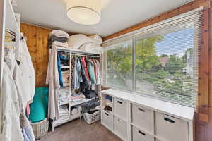 Spacious walk in closet with light colored carpet