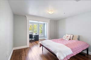 Bedroom featuring wood finished floors and a desk