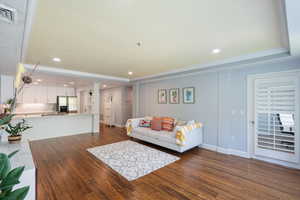 Living room featuring wood finished floors, recessed lighting, and a tray ceiling
