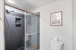 Full bath with a stall shower and a textured ceiling