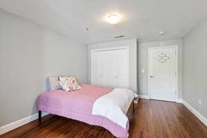 Bedroom with hardwood / wood-style flooring, a closet, and a textured ceiling